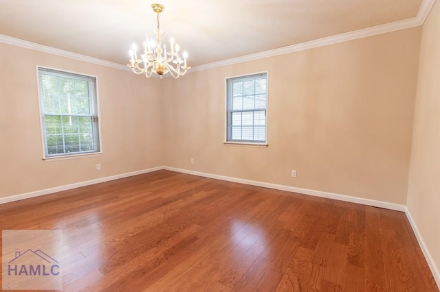 empty room featuring crown molding, hardwood / wood-style floors, and a chandelier