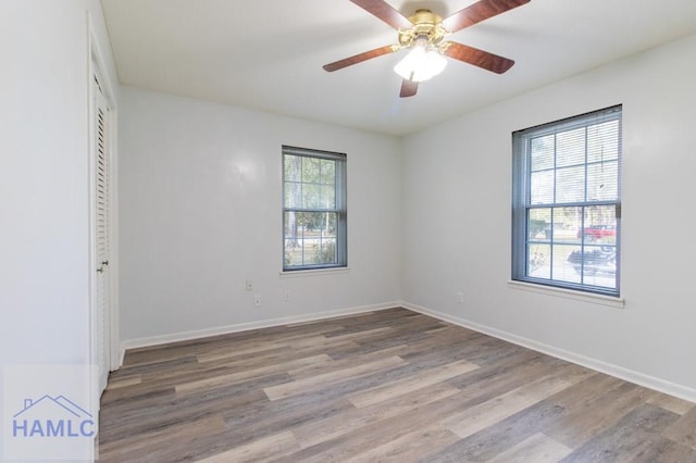 empty room featuring hardwood / wood-style flooring, ceiling fan, and a healthy amount of sunlight