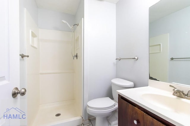 bathroom with vanity, toilet, and a shower