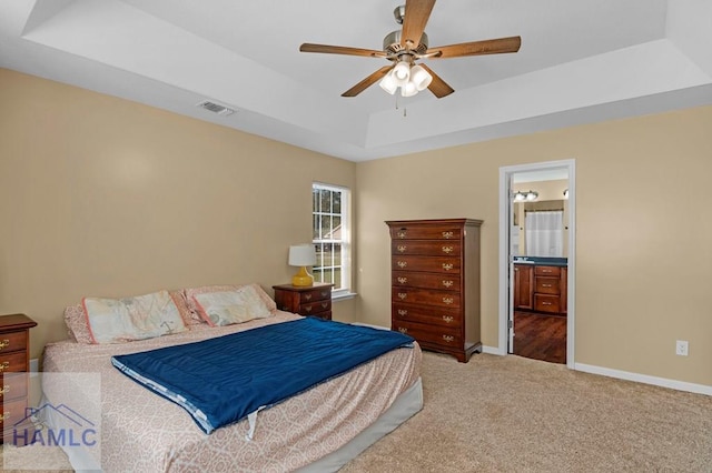 365 Carson St NE, Ludowici, GA 31316 - bedroom featuring a raised ceiling, carpet floors, baseboards, ensuite bath, and a ceiling fan