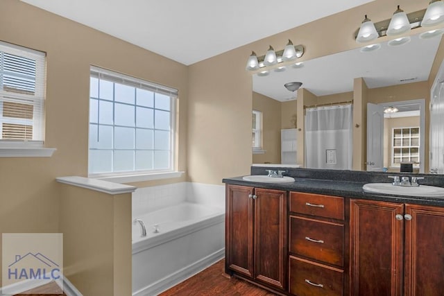 365 Carson St NE, Ludowici, GA 31316 - bathroom featuring a garden tub, double vanity, and wood finished floors