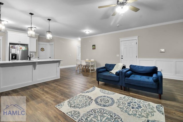 living room featuring crown molding, dark wood-type flooring, and ceiling fan