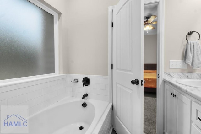 bathroom featuring vanity and tiled bath