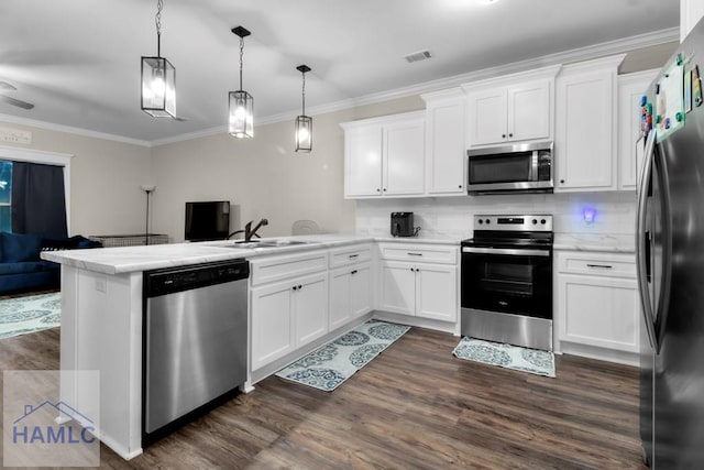 kitchen with appliances with stainless steel finishes, kitchen peninsula, sink, and white cabinets