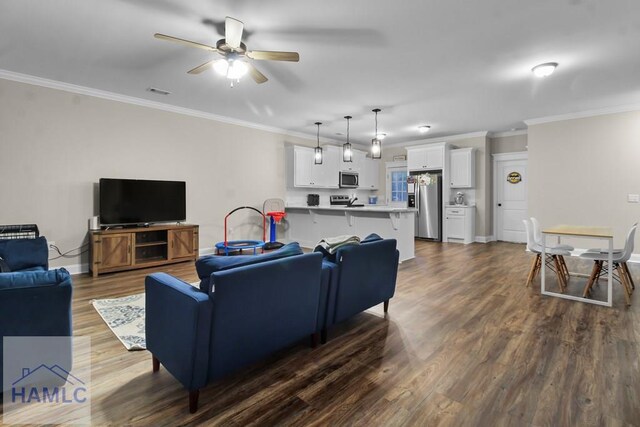 living room with ceiling fan, ornamental molding, and dark hardwood / wood-style floors