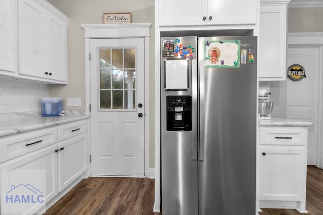 kitchen with light stone counters, dark wood-type flooring, stainless steel fridge with ice dispenser, and white cabinets