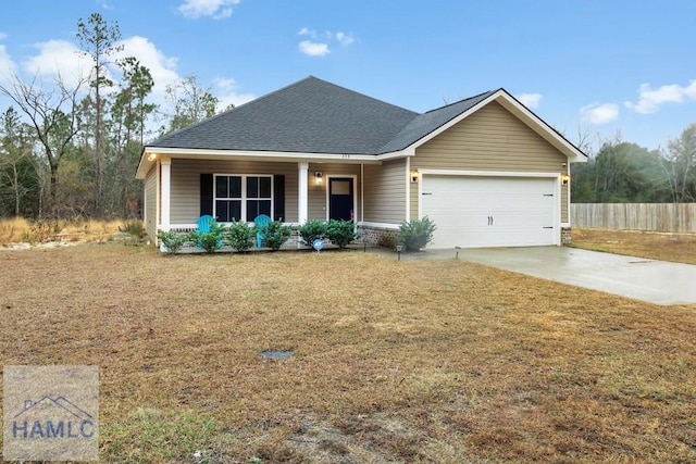 view of front of house featuring a garage, covered porch, and a front lawn