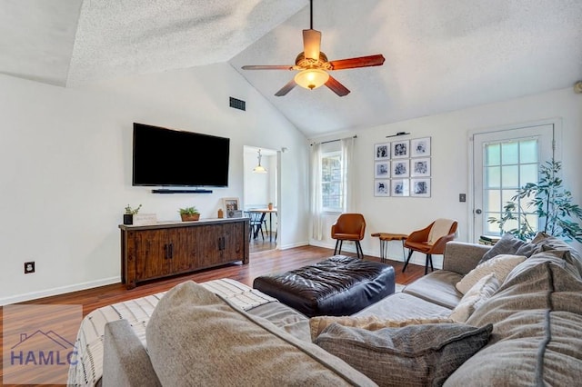 living room featuring baseboards, a ceiling fan, a textured ceiling, and wood finished floors