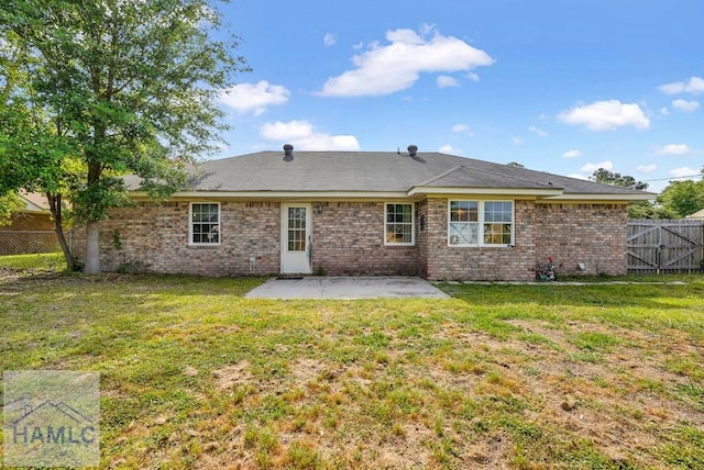 back of house featuring a yard, a patio, fence, and brick siding