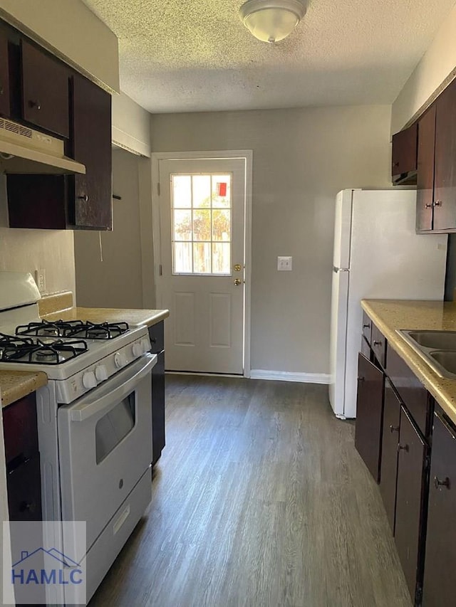 kitchen with white appliances, light wood-type flooring, dark brown cabinets, and a textured ceiling