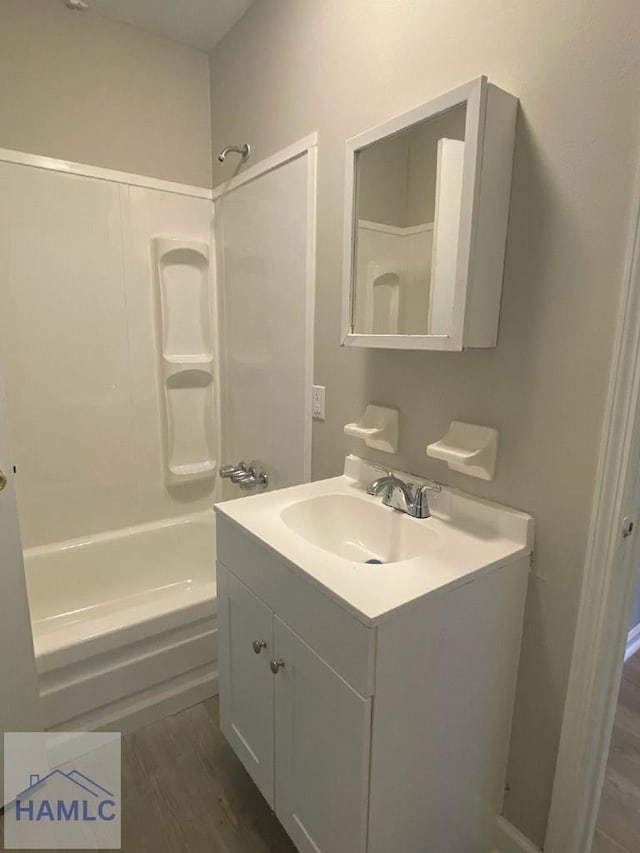 bathroom with vanity, hardwood / wood-style floors, and  shower combination