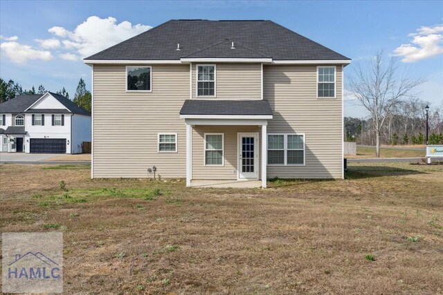 7 Summerhill Dr, Ludowici, GA 31316 - rear view of house featuring a lawn, a shingled roof, and a patio area