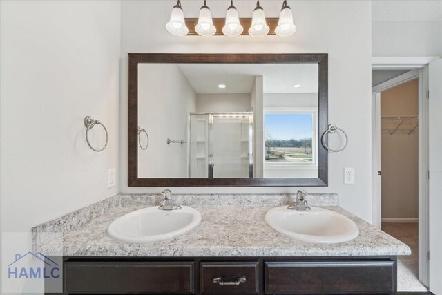 7 Summerhill Dr, Ludowici, GA 31316 - bathroom with double vanity, a spacious closet, a sink, and a stall shower
