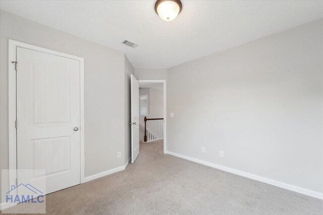 7 Summerhill Dr, Ludowici, GA 31316 - unfurnished bedroom with baseboards, visible vents, and light carpet