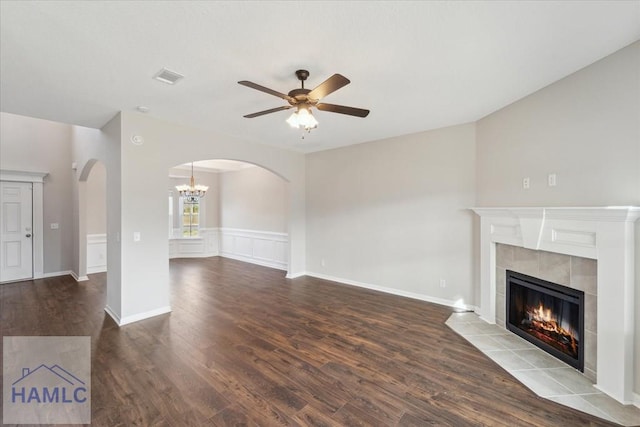 7 Summerhill Dr, Ludowici, GA 31316 - unfurnished living room featuring arched walkways, ceiling fan with notable chandelier, wood finished floors, and a tile fireplace