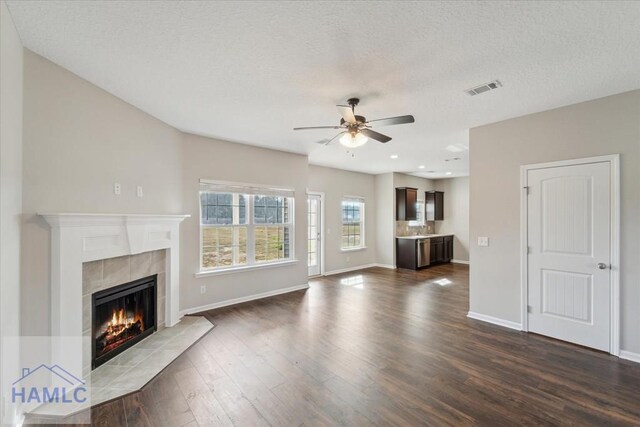 7 Summerhill Dr, Ludowici, GA 31316 - unfurnished living room featuring a fireplace, a ceiling fan, baseboards, visible vents, and dark wood-style floors