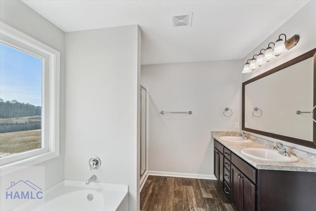 7 Summerhill Dr, Ludowici, GA 31316 - bathroom with visible vents, a sink, a garden tub, and wood finished floors
