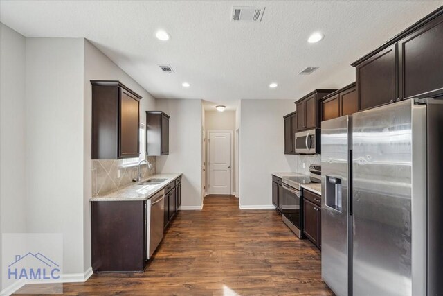 7 Summerhill Dr, Ludowici, GA 31316 - kitchen featuring dark wood-style flooring, visible vents, appliances with stainless steel finishes, dark brown cabinets, and a sink