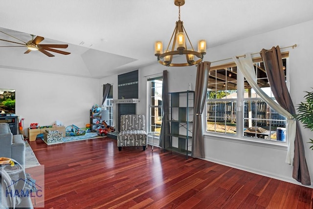 sitting room with dark wood-type flooring and ceiling fan with notable chandelier