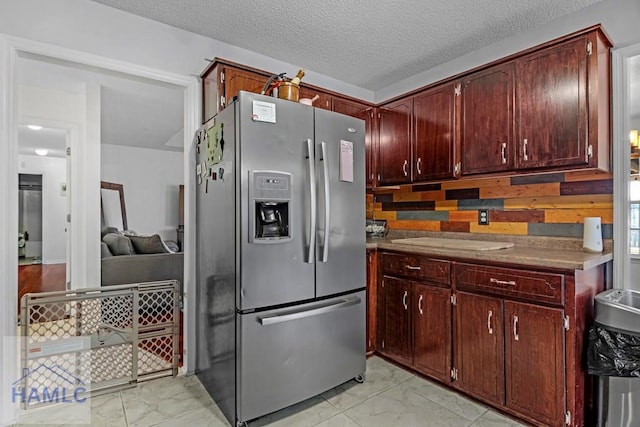 kitchen with tasteful backsplash, stainless steel fridge with ice dispenser, and a textured ceiling