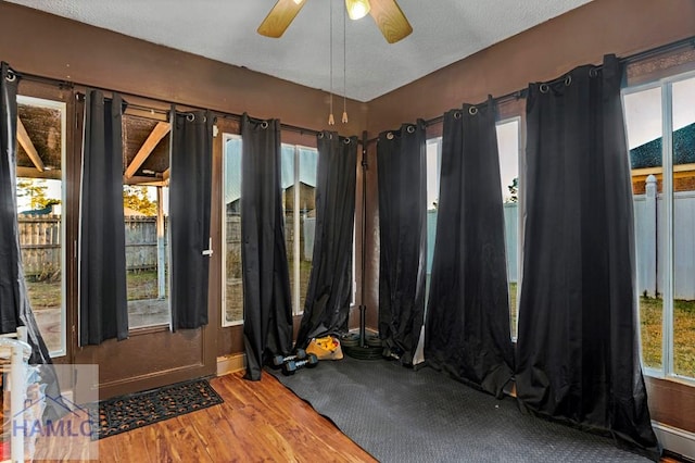 interior space with ceiling fan, hardwood / wood-style floors, and a textured ceiling