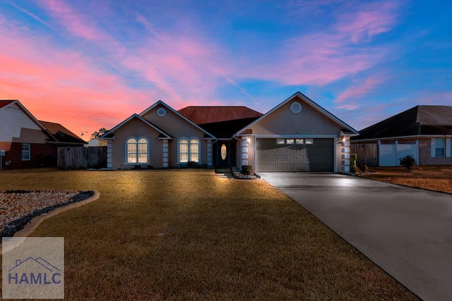 ranch-style home with a garage and a yard