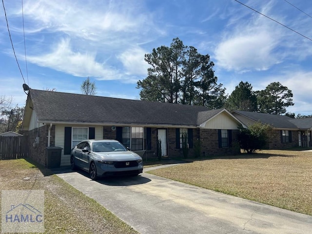 single story home featuring driveway, brick siding, roof with shingles, and a front yard