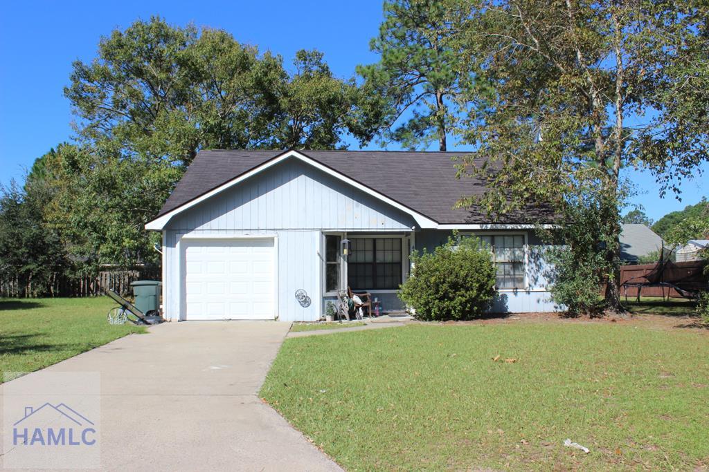 single story home featuring a garage and a front yard