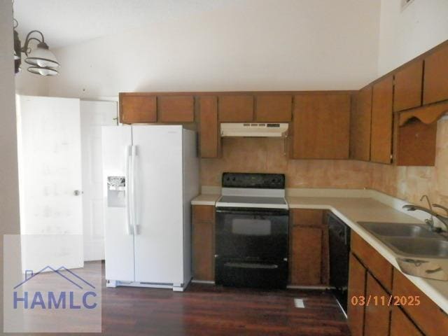 625 Oak St, Hinesville, GA 31313 - kitchen featuring electric range, under cabinet range hood, white fridge with ice dispenser, brown cabinetry, and light countertops