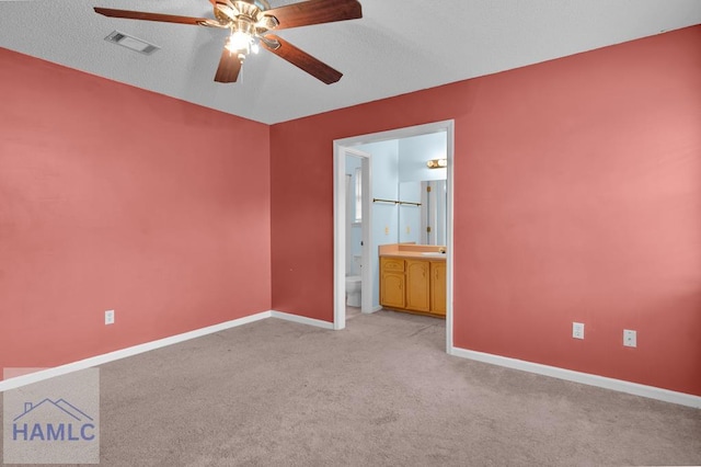 spare room with a textured ceiling, ceiling fan, and light carpet