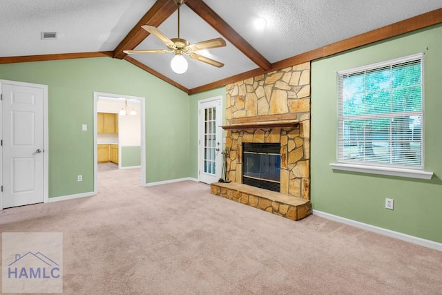 unfurnished living room with light carpet, a textured ceiling, ceiling fan, lofted ceiling with beams, and a stone fireplace