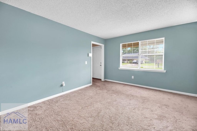 carpeted empty room with a textured ceiling