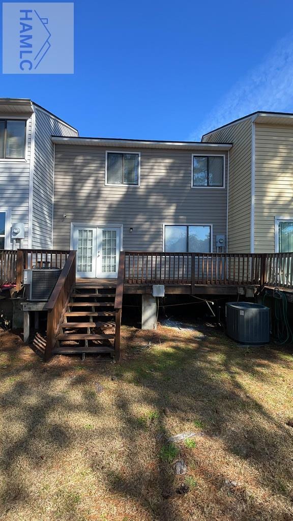 rear view of house with a deck, french doors, and cooling unit