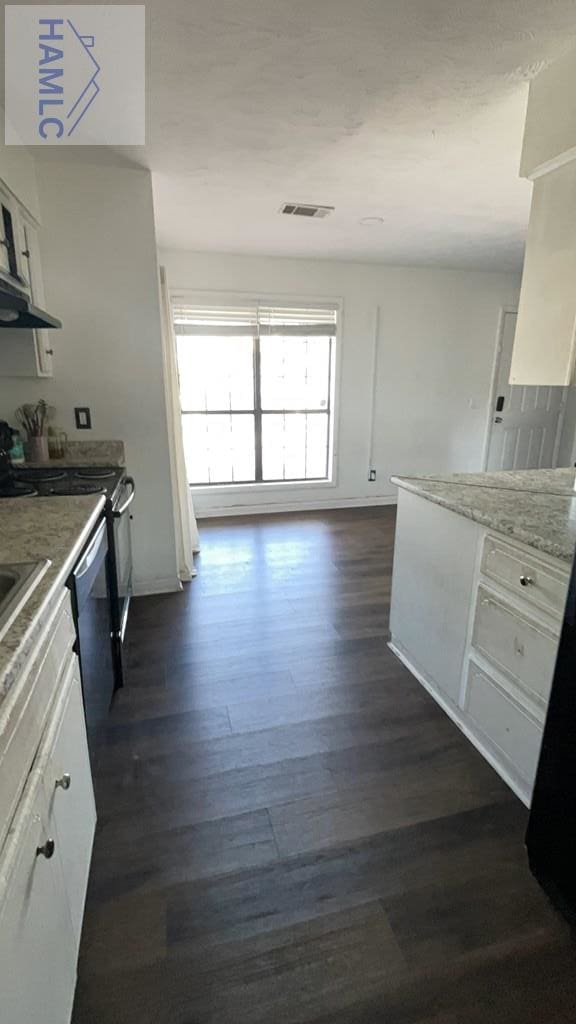 kitchen with range with electric cooktop, visible vents, white cabinets, dark wood finished floors, and light stone counters