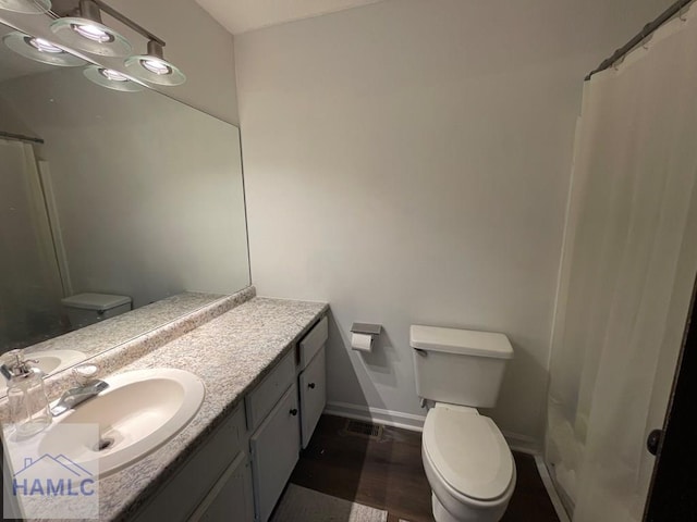 full bathroom featuring visible vents, baseboards, toilet, wood finished floors, and vanity