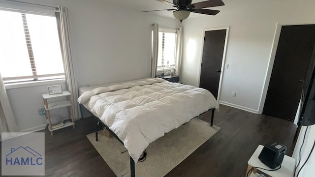 bedroom with dark wood-style floors, baseboards, and a ceiling fan