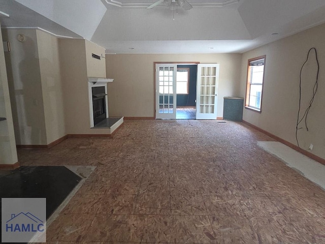 5927 Yellow Bluff Rd, Blackshear, GA 31516 - unfurnished living room featuring healthy amount of natural light, a ceiling fan, a fireplace with raised hearth, and french doors