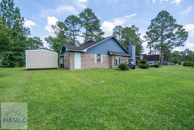 901 Pintail Ct, Hinesville, GA 31313 - view of side of property featuring brick siding, a yard, a chimney, and a storage shed