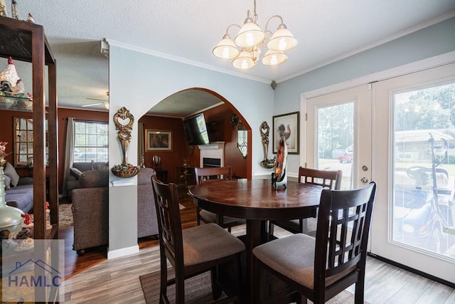 901 Pintail Ct, Hinesville, GA 31313 - dining space featuring arched walkways, light wood-style flooring, a chandelier, crown molding, and ceiling fan