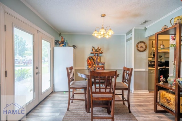 901 Pintail Ct, Hinesville, GA 31313 - dining room featuring french doors, crown molding, wood finished floors, a chandelier, and a textured ceiling