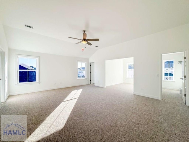 carpeted spare room featuring vaulted ceiling and ceiling fan