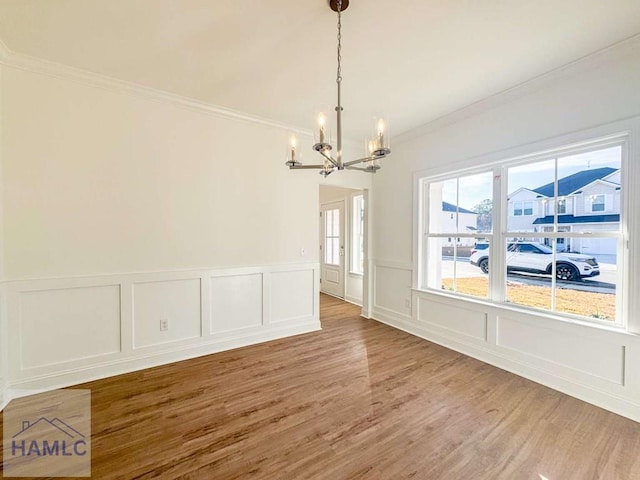 dining space featuring hardwood / wood-style flooring, crown molding, and a notable chandelier