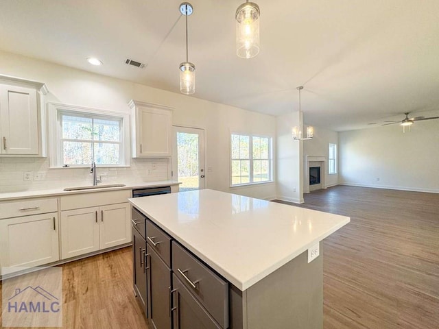 kitchen featuring white cabinets, plenty of natural light, sink, and light hardwood / wood-style flooring