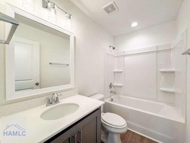 full bathroom featuring toilet, hardwood / wood-style floors, vanity, and tub / shower combination