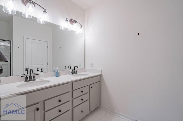 bathroom featuring tile patterned floors, double vanity, and baseboards