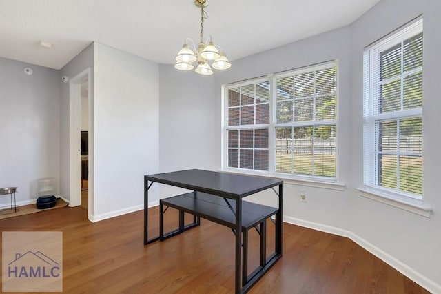 dining space with a notable chandelier and dark hardwood / wood-style flooring