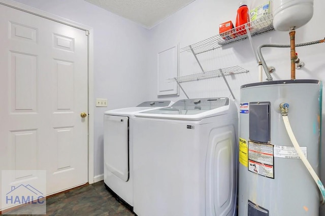 laundry area with water heater and washing machine and clothes dryer