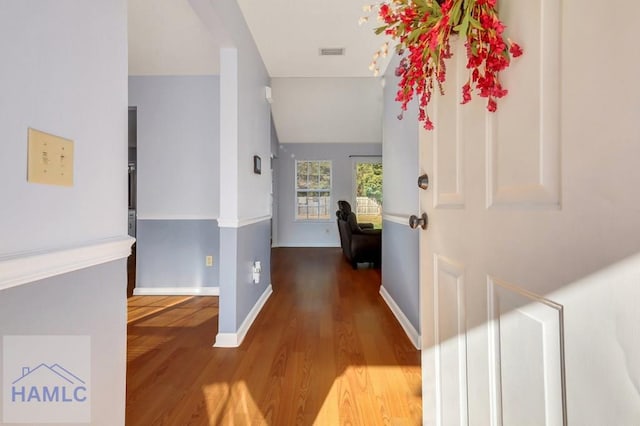 hallway with lofted ceiling and hardwood / wood-style floors