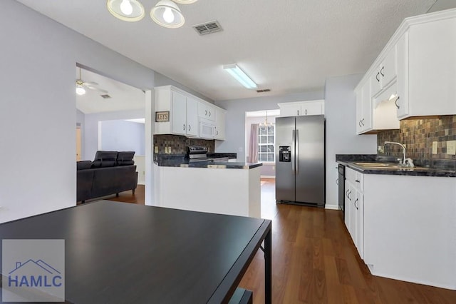 kitchen with appliances with stainless steel finishes, white cabinetry, sink, ceiling fan, and dark wood-type flooring