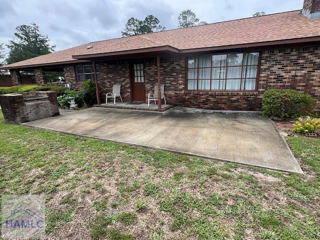 224 Bacon St, Jesup, GA 31545 - back of house featuring a patio, brick siding, and a lawn
